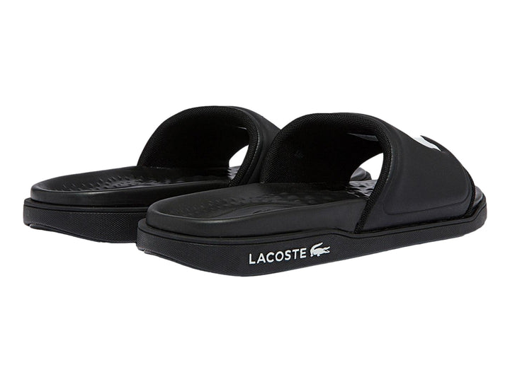Sandalia Lacoste de color negro con logotipo blanco en la banda y suela negra.