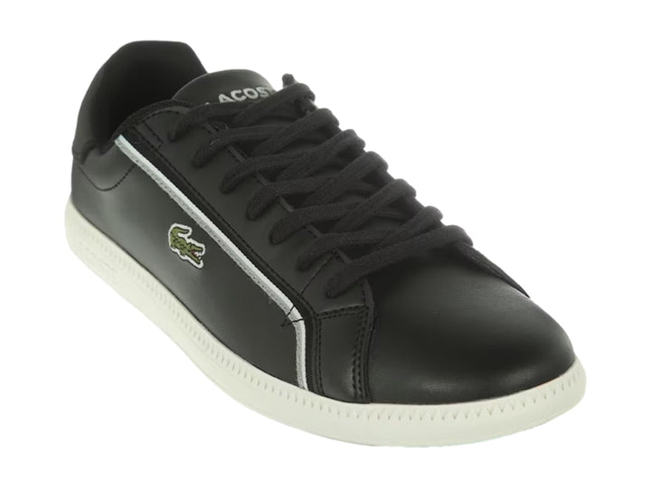Tenis Lacoste color negro con suela blanca y detalle de línea blanca lateral.