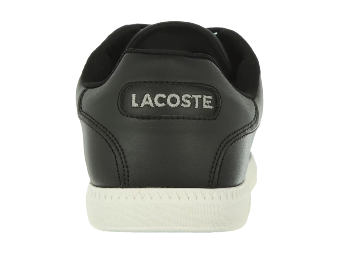 Tenis Lacoste color negro con suela blanca y detalle de línea blanca lateral.