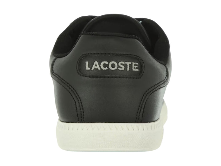 Tenis Lacoste color negro con suela blanca y detalle de línea blanca lateral.