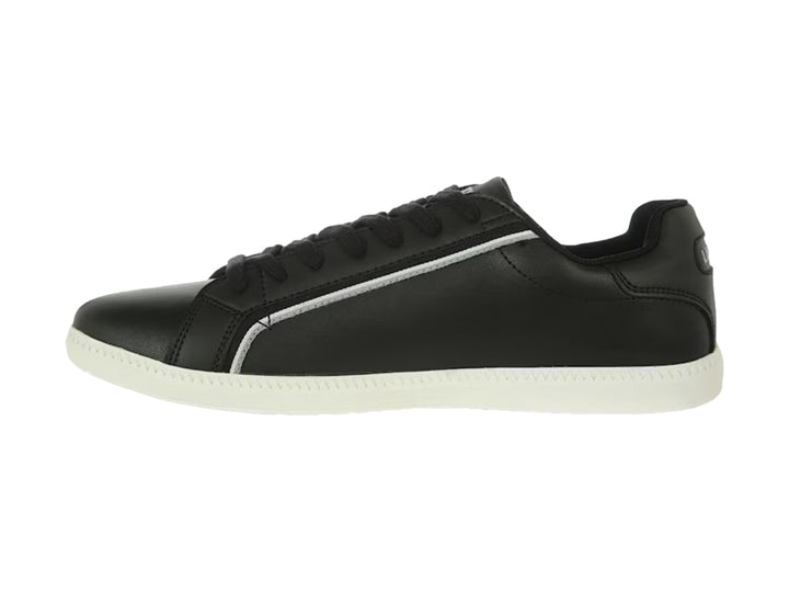 Tenis Lacoste color negro con suela blanca y detalle de línea blanca lateral.
