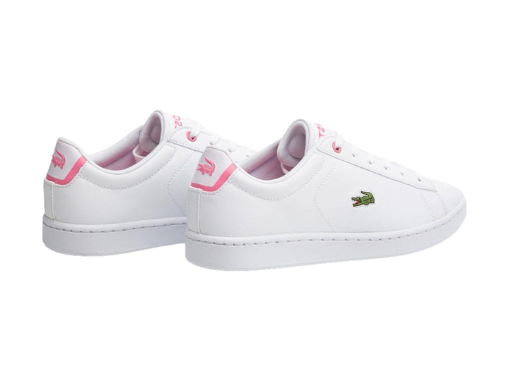 Tenis Lacoste blancos con detalles en color rosa y logotipo del cocodrilo verde en el lateral.
