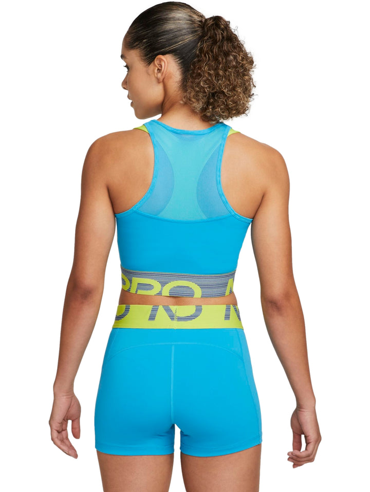 Mujer vistiendo un crop top deportivo azul con detalles en verde neón y gris de la marca Nike.
