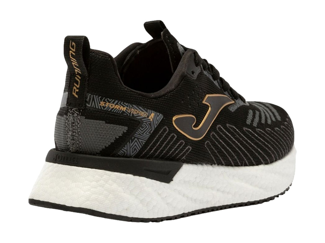 Tenis deportivos Joma color negro con detalles dorados y suela blanca.