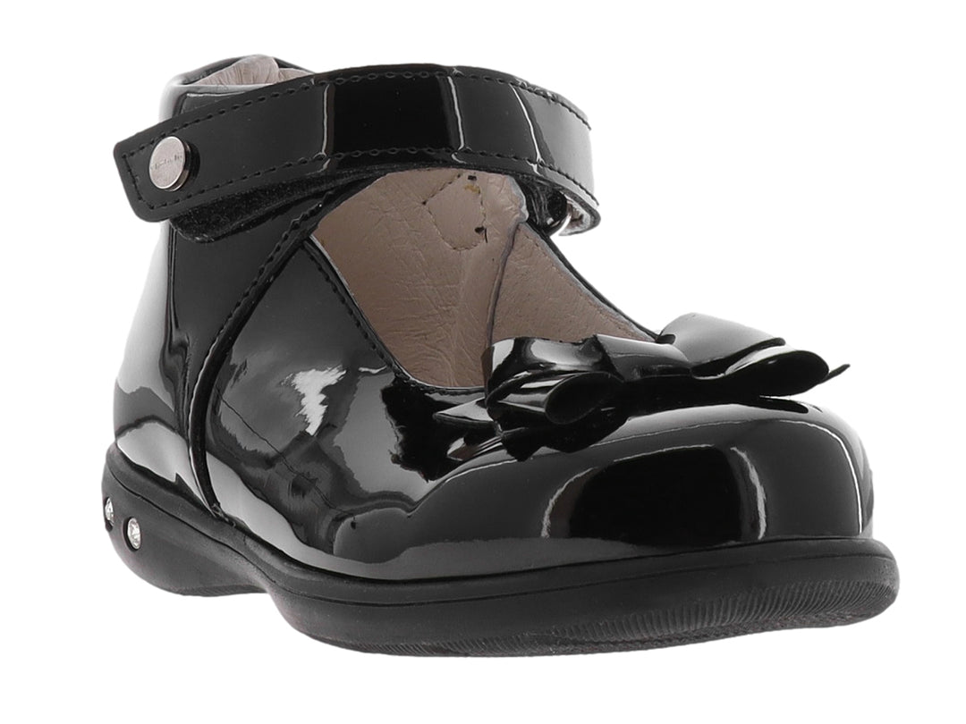 Zapato negro de charol para niña con moño decorativo y correa ajustable.