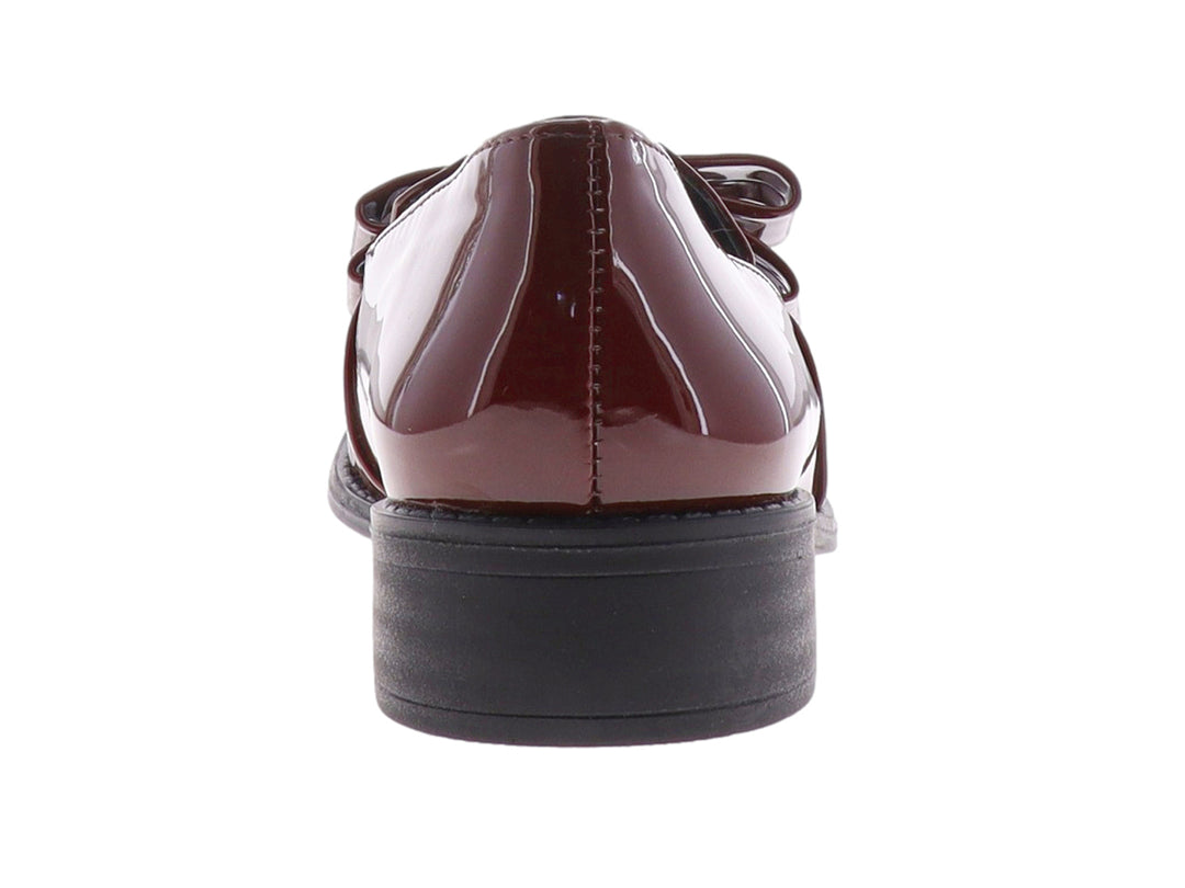 Zapato de charol color vino con moño decorativo y suela negra.