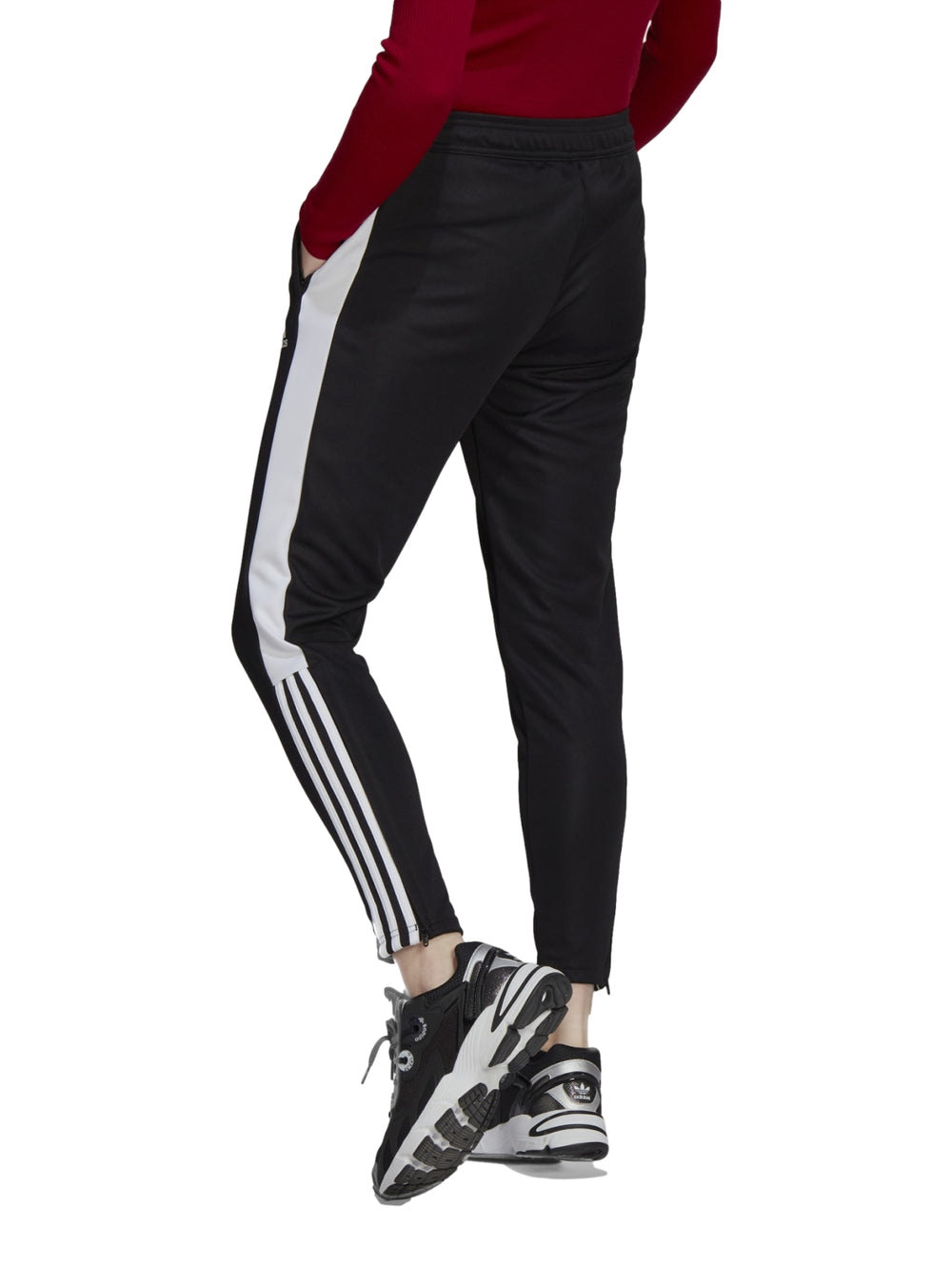 Pantalones deportivos Adidas color negro con tres franjas blancas laterales y corte ajustado.