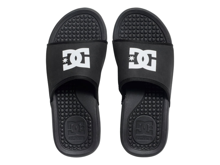 Sandalia tipo slider color negro con logotipo blanco de DC Shoes en la banda superior.