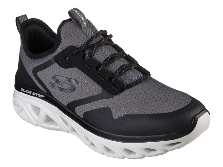 Tenis deportivos Skechers en colores gris y negro con suela blanca tecnológica Glide-Step.
