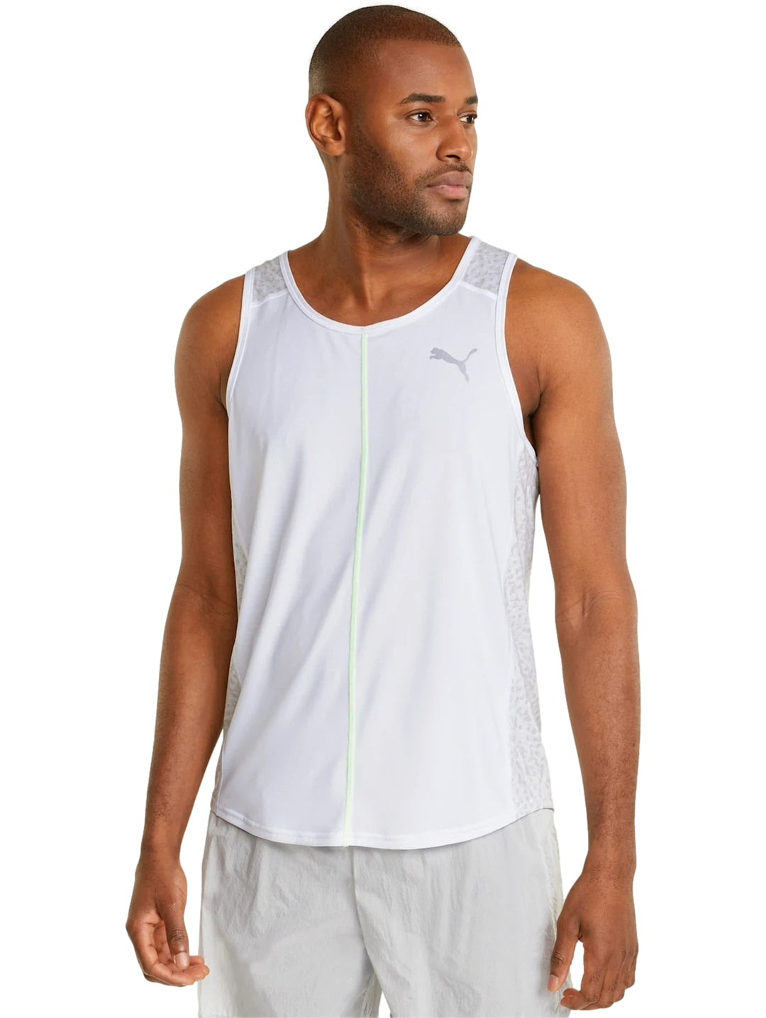 Hombre vistiendo camiseta deportiva PUMA blanca sin mangas con detalle en verde neón y shorts blancos.