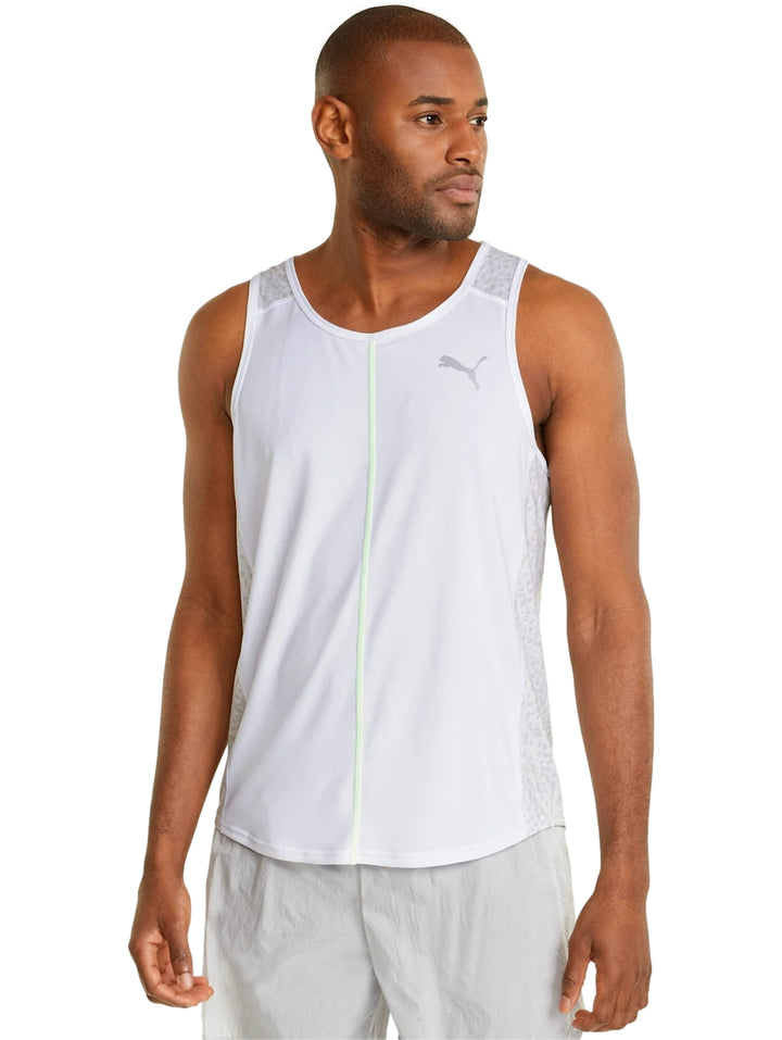 Hombre vistiendo camiseta deportiva PUMA blanca sin mangas con detalle en verde neón y shorts blancos.