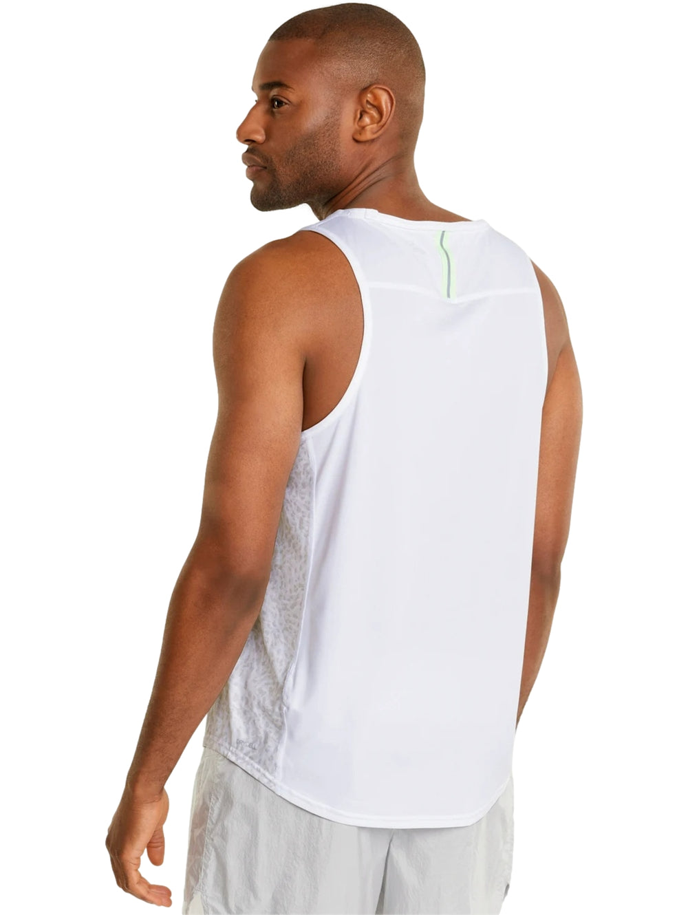 Hombre vistiendo camiseta deportiva PUMA blanca sin mangas con detalle en verde neón y shorts blancos.