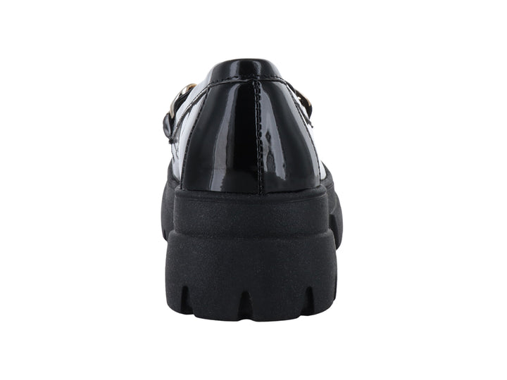Mocasín negro de charol con suela track gruesa y detalle de cadena dorada.