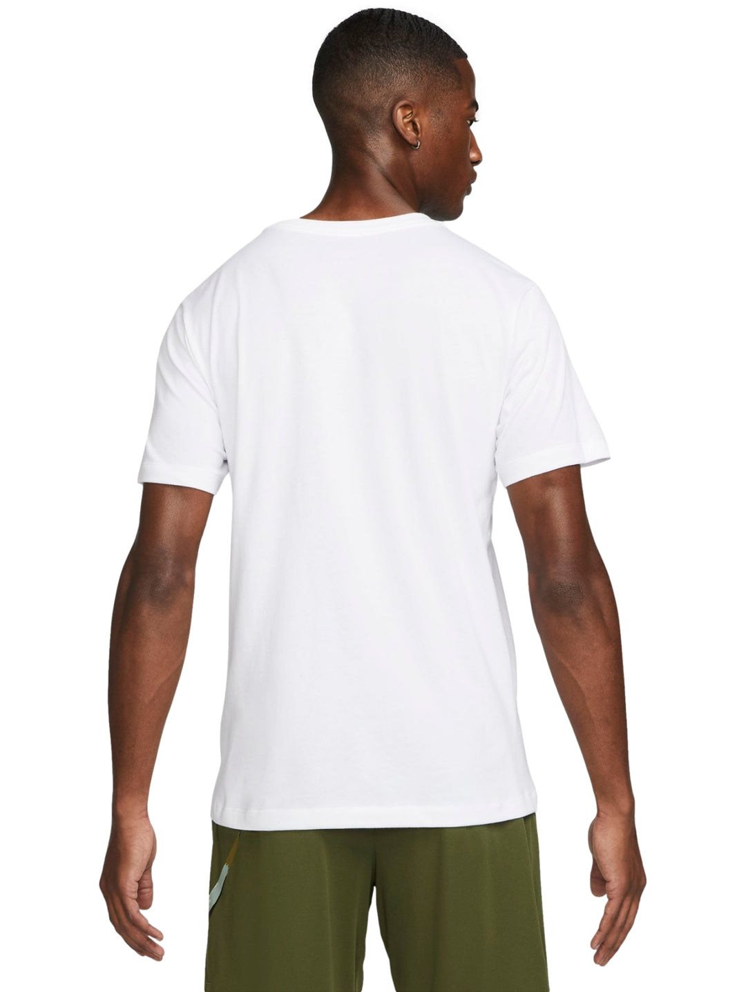 Hombre vistiendo una playera Nike de color blanco con logotipo en el pecho y pantalones cortos verde oliva.