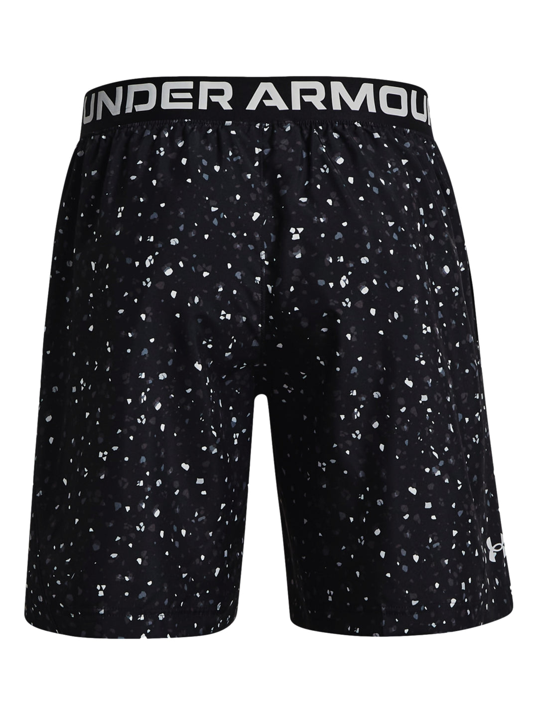 Hombre vistiendo shorts deportivos Under Armour color negro con estampado de pequeños puntos blancos.