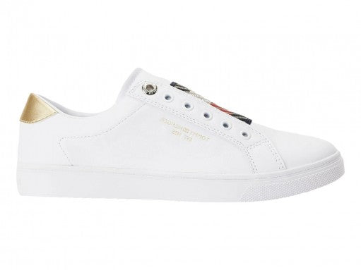 Tenis blancos Tommy Hilfiger estilo slip-on con detalle dorado en el talón y suela blanca.