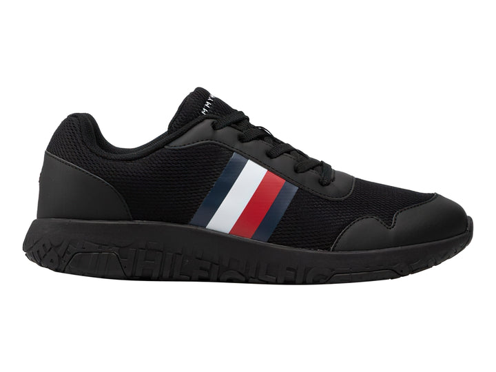Tenis deportivos Tommy Hilfiger color negro con franja tricolor en el lateral y suela negra.