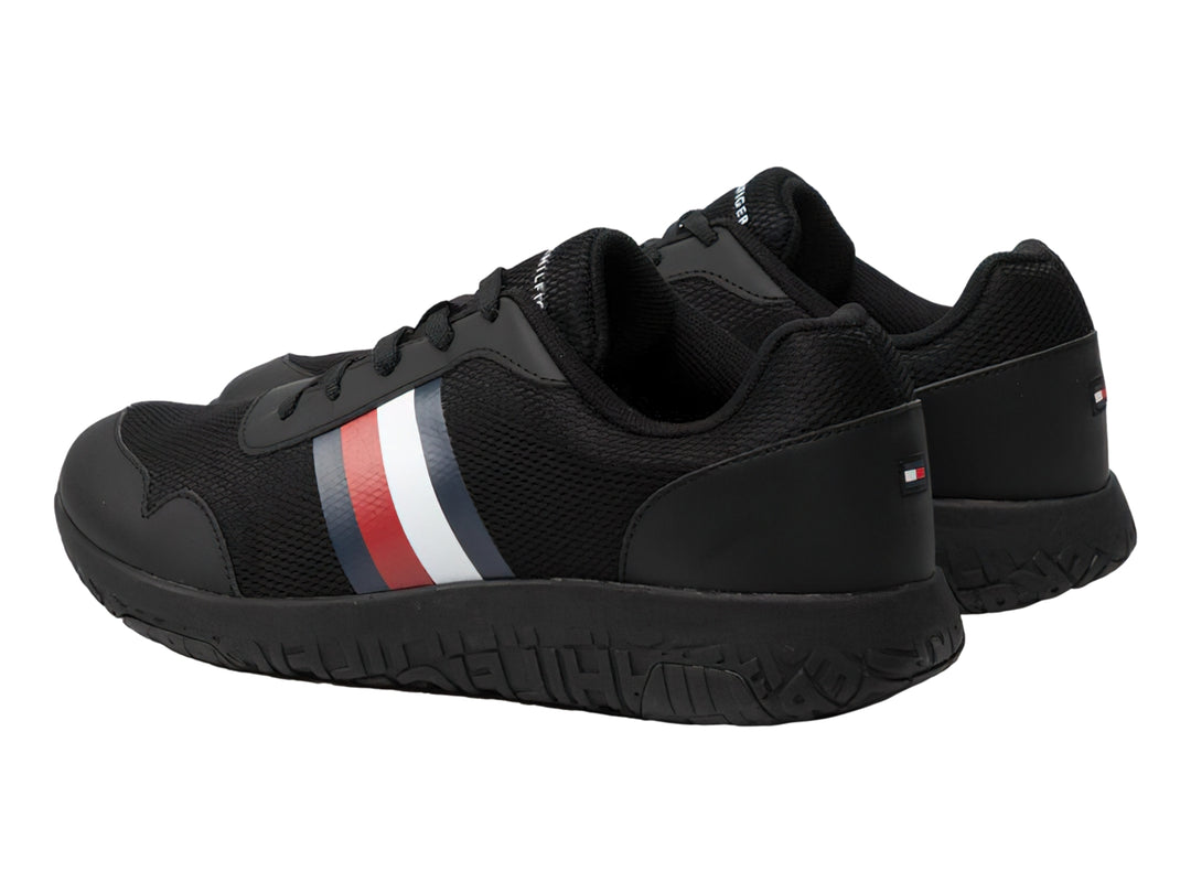 Tenis deportivos Tommy Hilfiger color negro con franja tricolor en el lateral y suela negra.