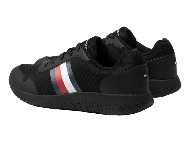 Tenis deportivos Tommy Hilfiger color negro con franja tricolor en el lateral y suela negra.