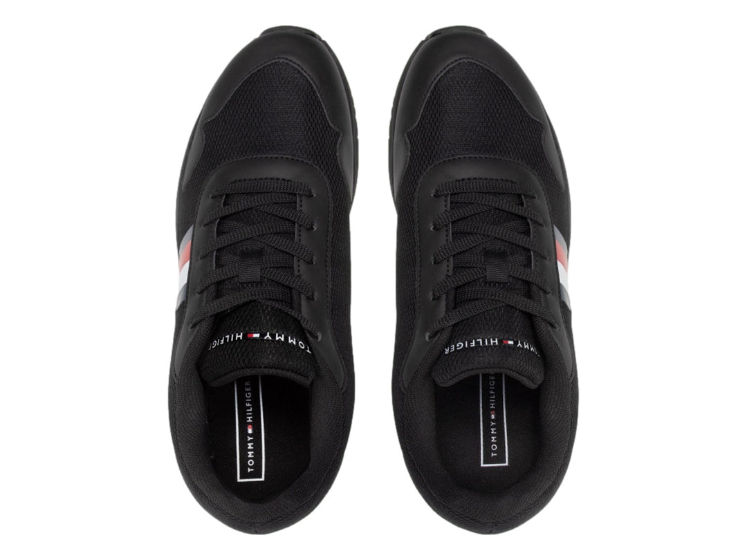 Tenis deportivos Tommy Hilfiger color negro con franja tricolor en el lateral y suela negra.