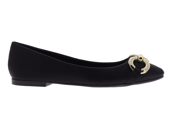 Zapato plano color negro con un adorno circular dorado en la parte frontal.