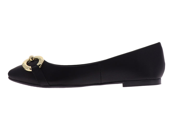 Zapato plano color negro con un adorno circular dorado en la parte frontal.