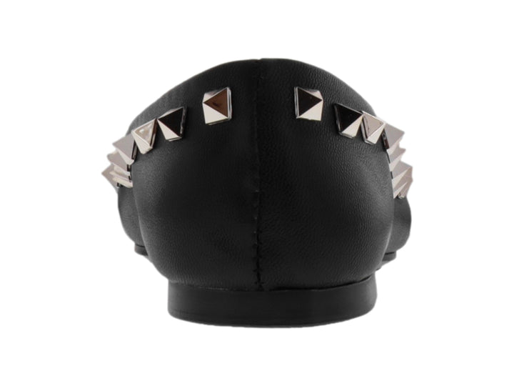 Zapato plano negro de piel con tachuelas plateadas en forma de pirámide.
