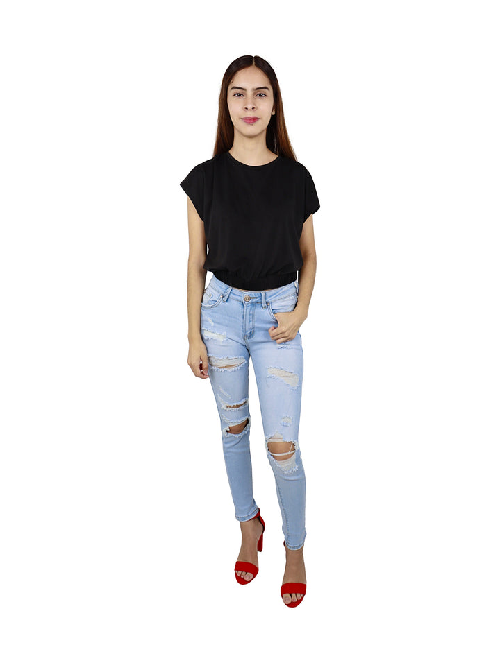 Mujer joven vistiendo una blusa negra de manga corta y pantalones vaqueros azul claro.