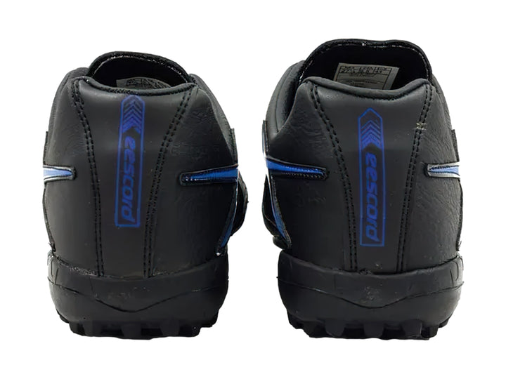 Zapato de fútbol Eescord color negro con detalles en azul y suela para césped sintético.