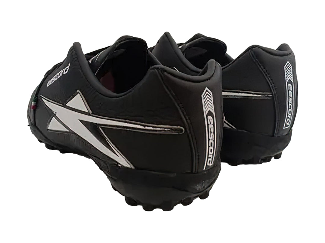 Zapato de fútbol EESCORD color negro con detalles en blanco y suela para turf.