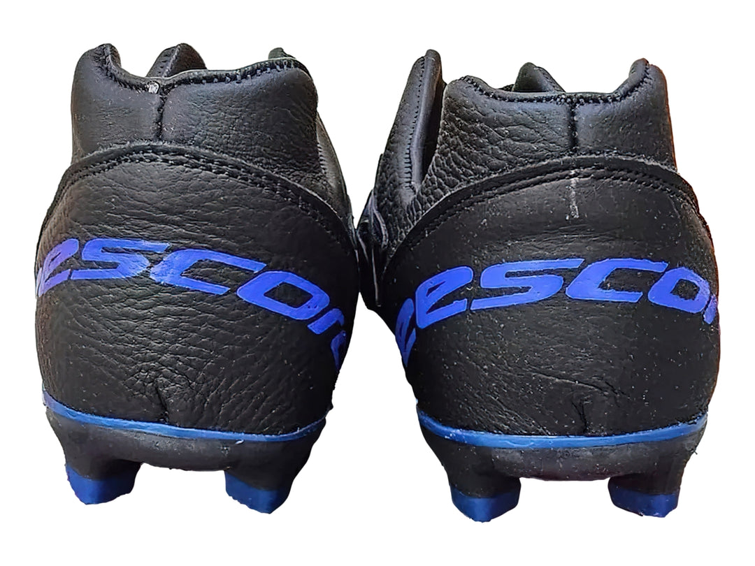 Zapato de fútbol EESCORD color negro con detalles en azul y suela de tacos para césped.