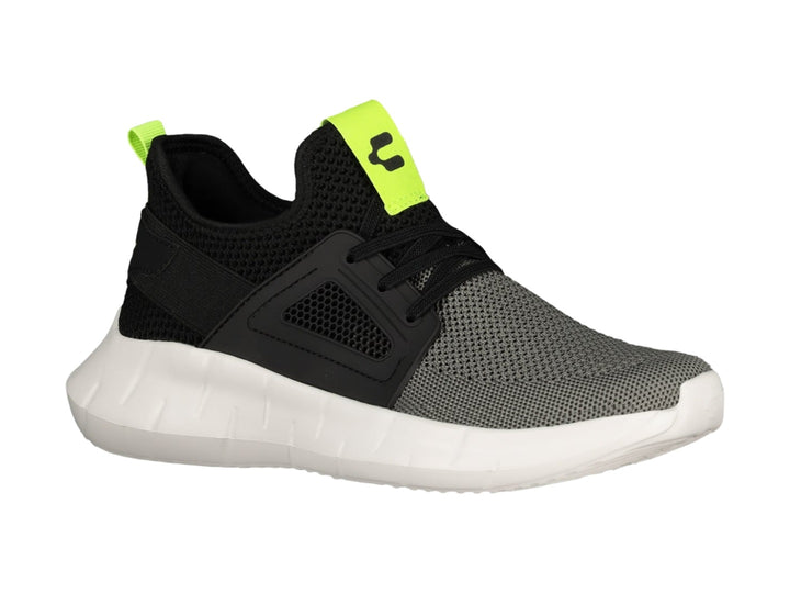 Tenis deportivos Charly color negro y gris con suela blanca y detalles en amarillo neón.
