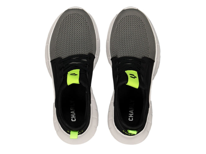 Tenis deportivos Charly color negro y gris con suela blanca y detalles en amarillo neón.