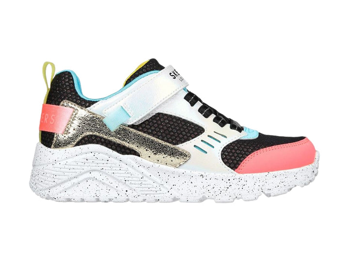 Tenis deportivos Skechers infantiles en colores negro, blanco, rosa y dorado con correa de velcro.