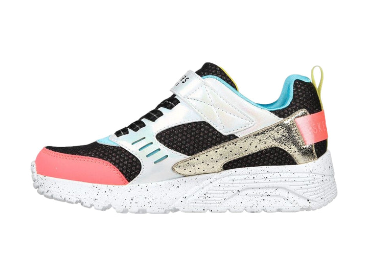 Tenis deportivos Skechers infantiles en colores negro, blanco, rosa y dorado con correa de velcro.