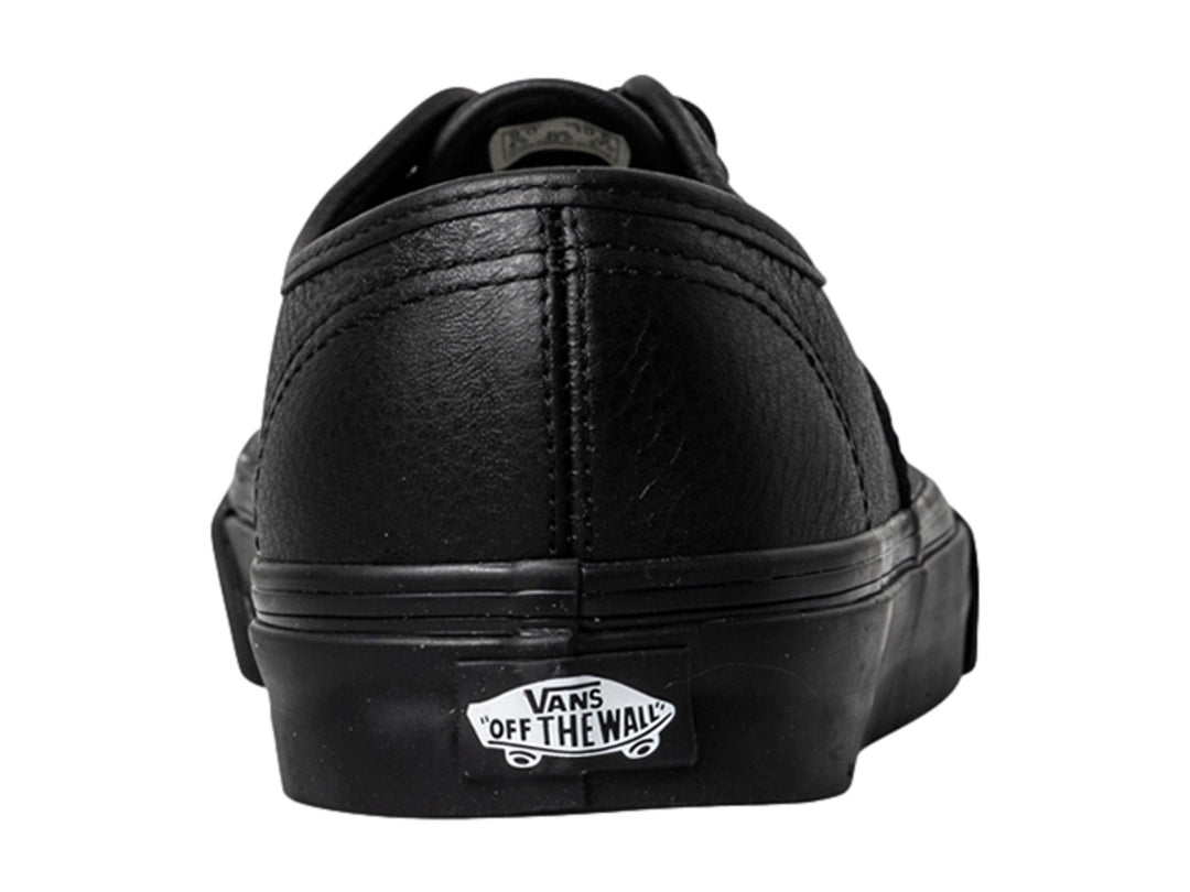 Tenis Vans Authentic de cuero color negro con agujetas y suela a juego.