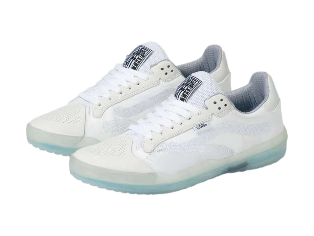 Tenis deportivos Vans color blanco con suela translúcida en tono celeste claro.