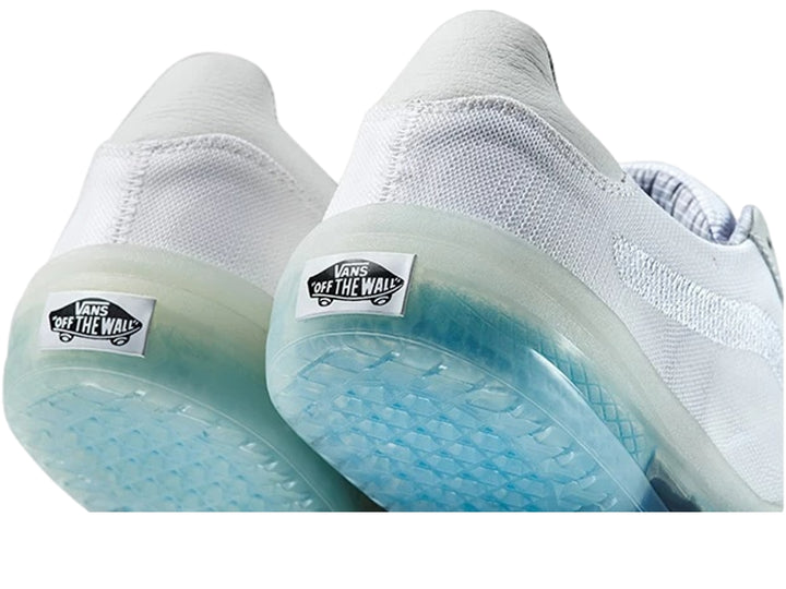 Tenis deportivos Vans color blanco con suela translúcida en tono celeste claro.