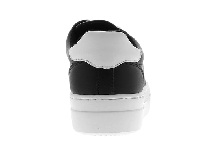 Tenis Nine West color negro con suela de plataforma blanca y ojillos dorados.