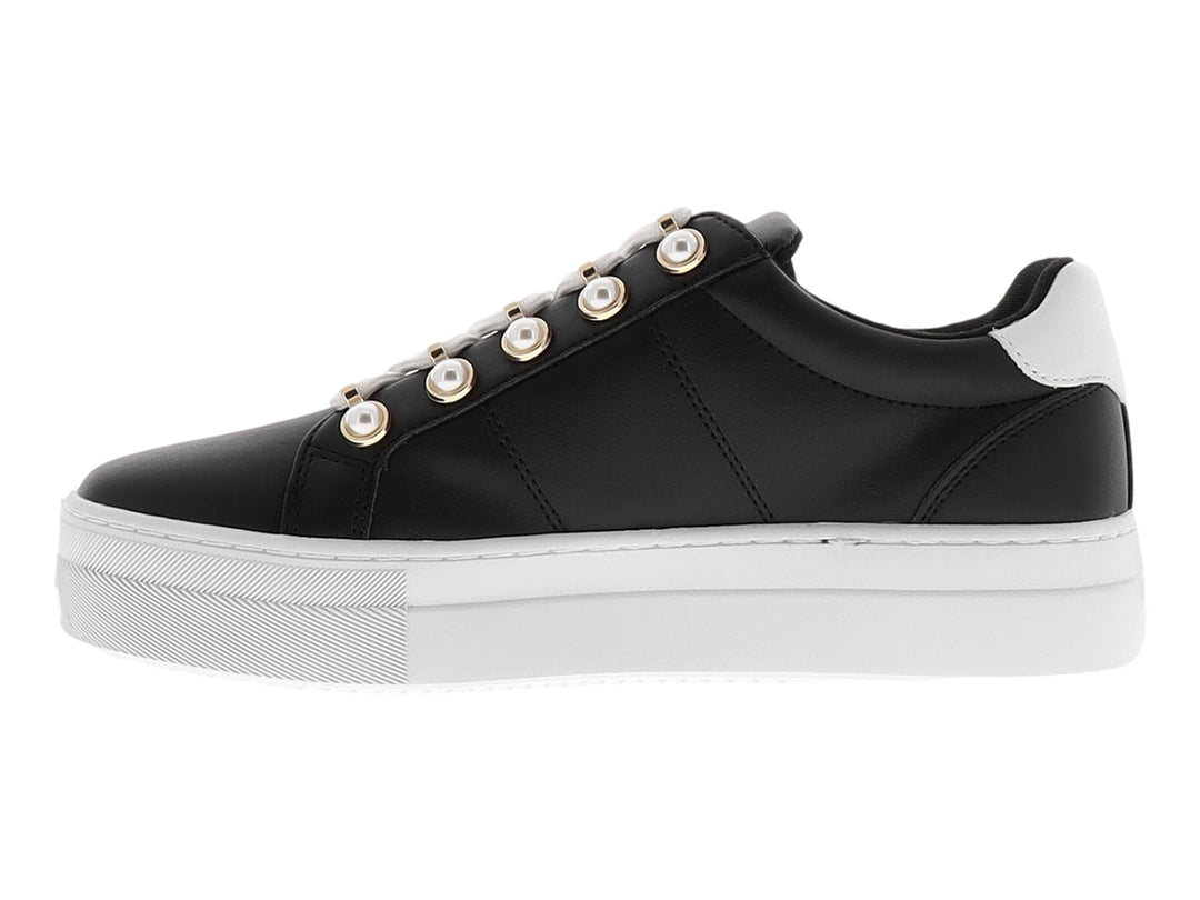 Tenis Nine West color negro con suela de plataforma blanca y ojillos dorados.