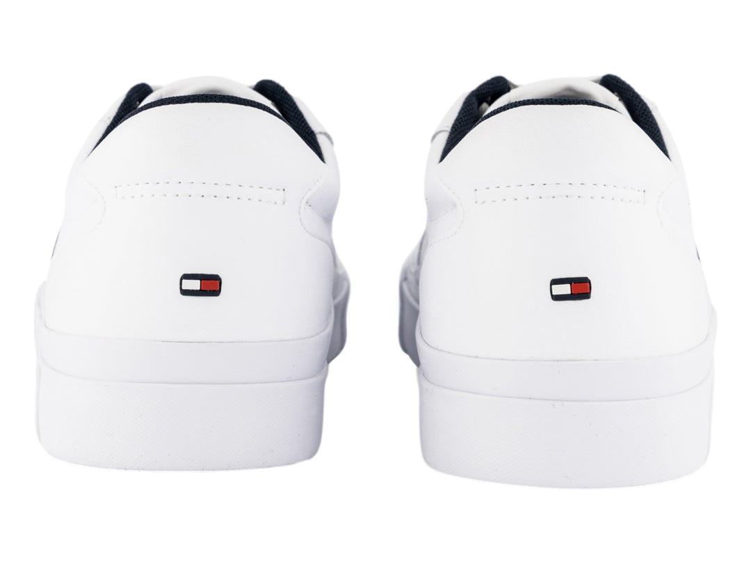 Tenis blancos de cuero Tommy Hilfiger con detalles laterales en azul y rojo y suela blanca.