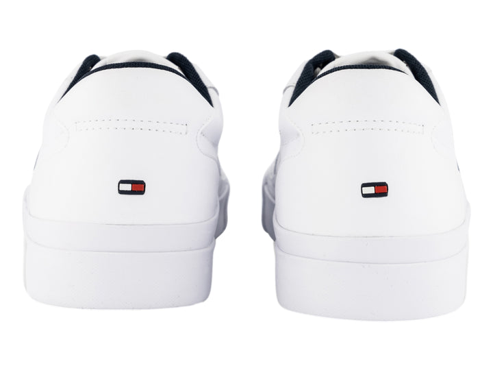 Tenis blancos de cuero Tommy Hilfiger con detalles laterales en azul y rojo y suela blanca.