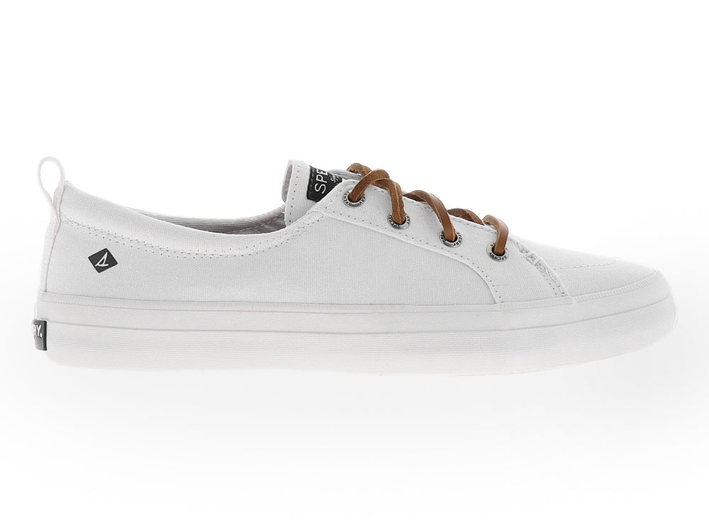 Zapato Sperry de lona color blanco con cordones en tono café y suela blanca.