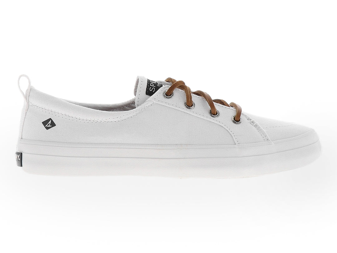 Zapato Sperry de lona color blanco con cordones en tono café y suela blanca.
