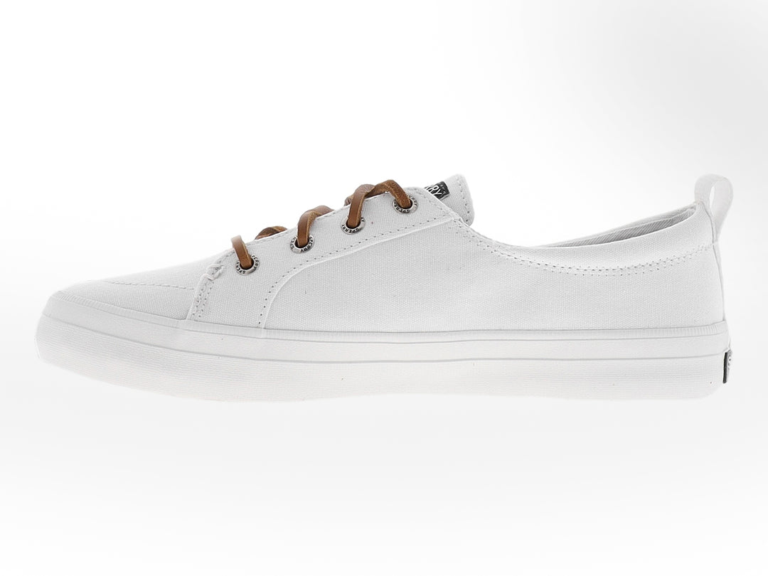Zapato Sperry de lona color blanco con cordones en tono café y suela blanca.