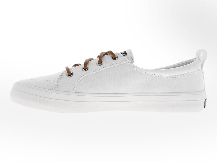 Zapato Sperry de lona color blanco con cordones en tono café y suela blanca.