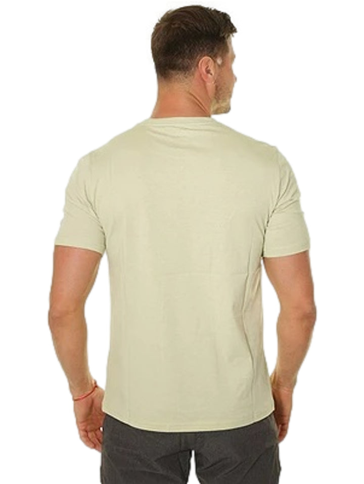 Hombre vistiendo playera Converse color verde oliva con logotipo blanco en el pecho.