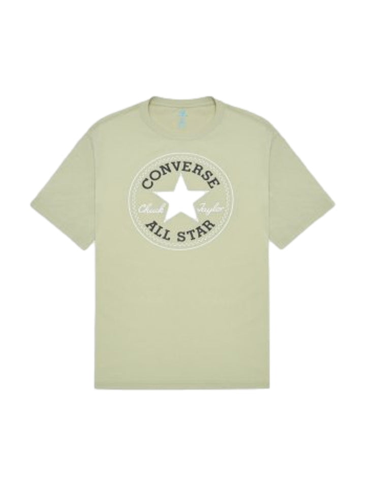 Hombre vistiendo playera Converse color verde oliva con logotipo blanco en el pecho.