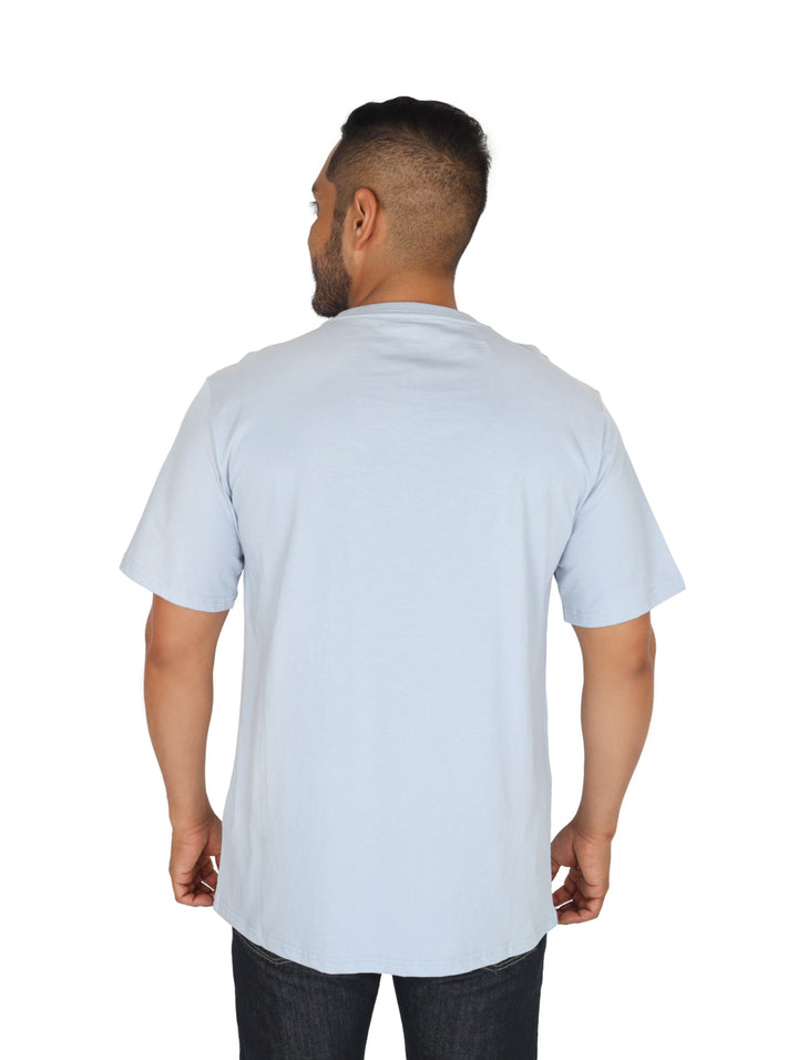 Hombre usando una playera Converse de color azul claro con logotipo blanco en el pecho.