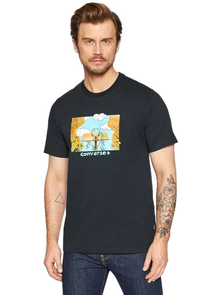 Hombre vistiendo playera negra de manga corta con estampado gráfico colorido en el pecho de la marca Converse.
